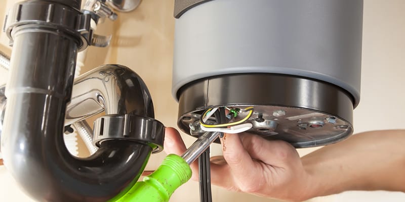 Technician repairing the heating element of a water heater in Colton