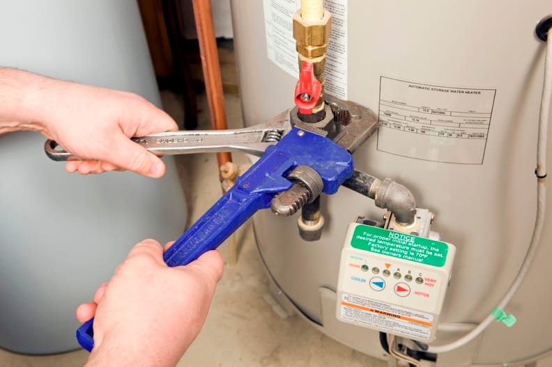 Plumber repairing a water heater valve in Colton